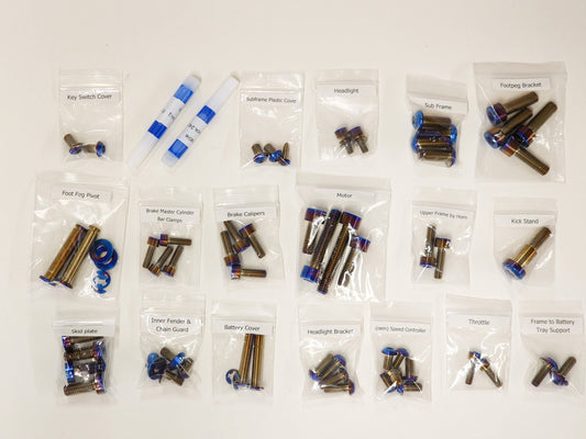 Titanium chassis bolt kit laid out for the Surron Light Bee X