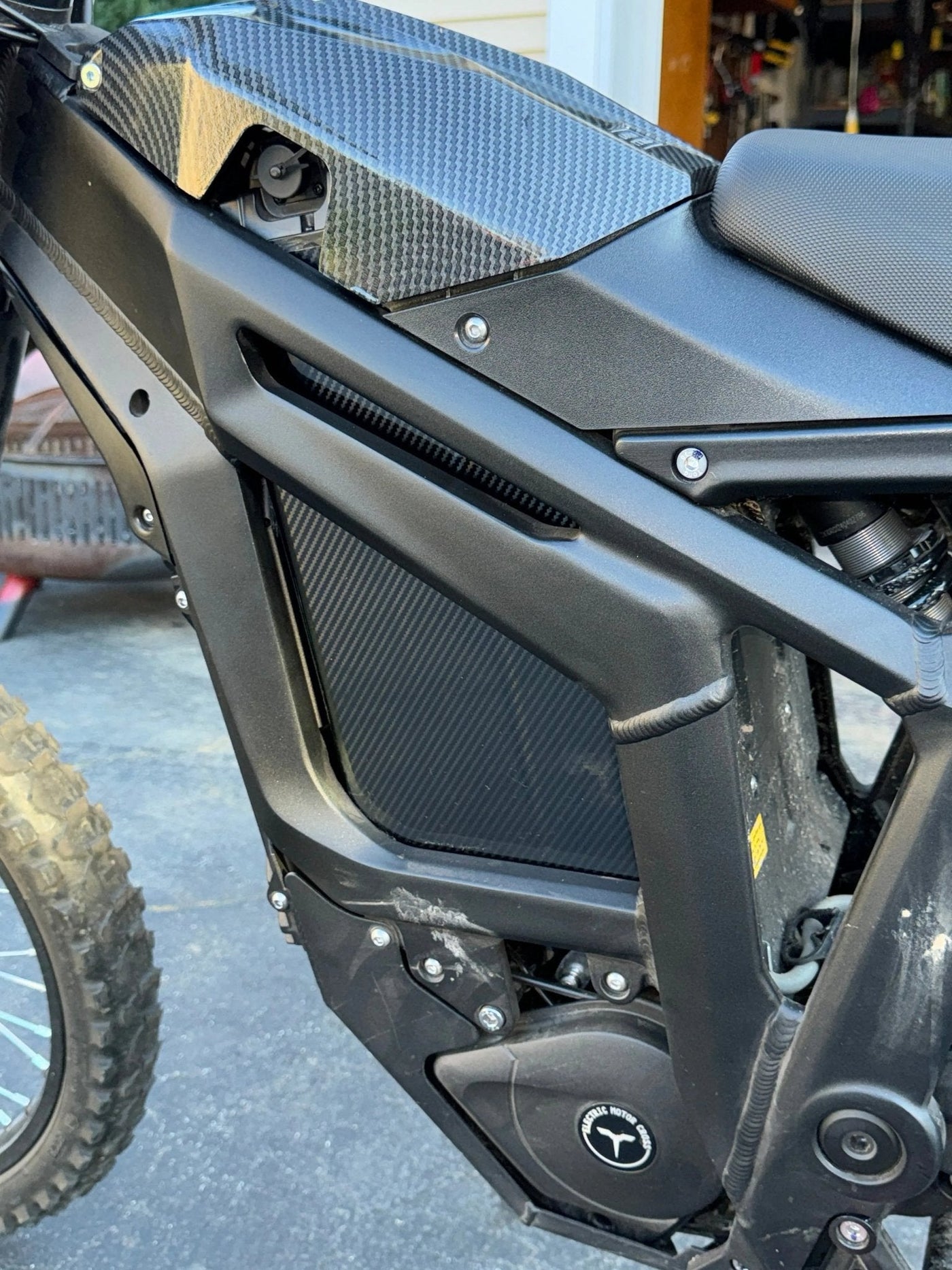 Carbon fiber battery wrap installed on e-moto battery in sunlight