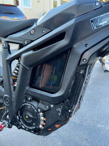 Carbon fiber battery wrap installed on e-moto battery in shade