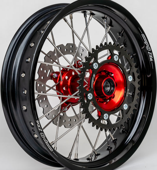 Close-up of Warp 9 Honda CRF rear wheel hub — red anodized billet hub with black sprocket and 240mm rotor
